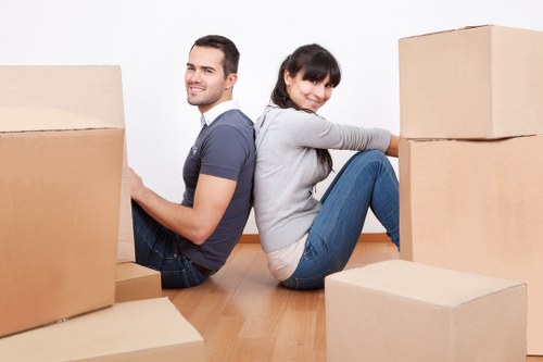 Professional business movers packing office equipment for relocation